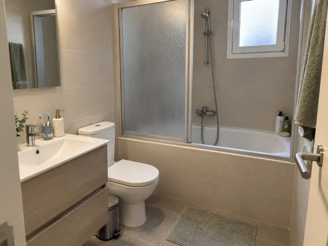 Antes: bañera con mampara abatible de vidrio translúcido